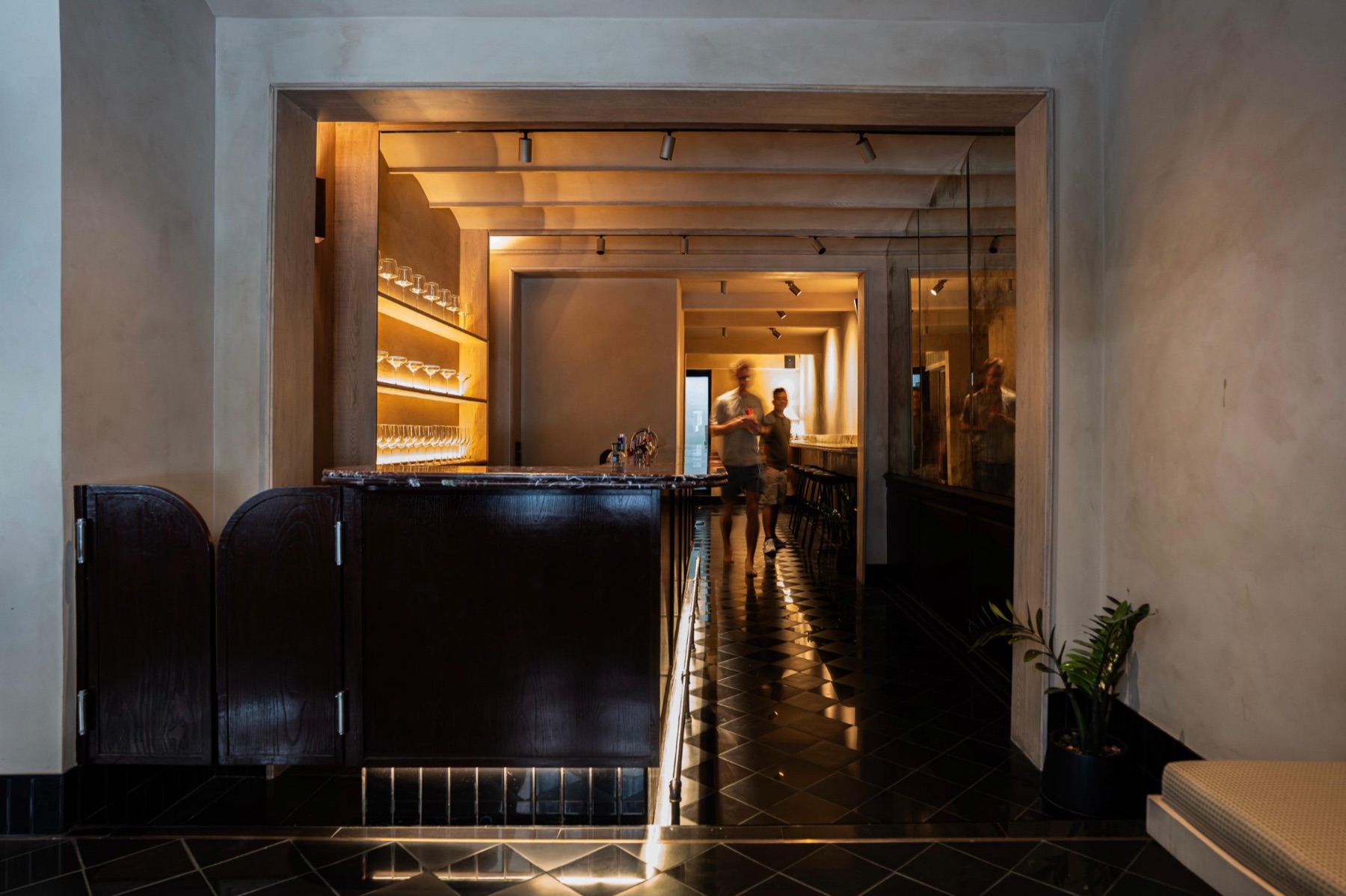 The finished ground floor: the bar and a checkerboard floor running to the back of the house