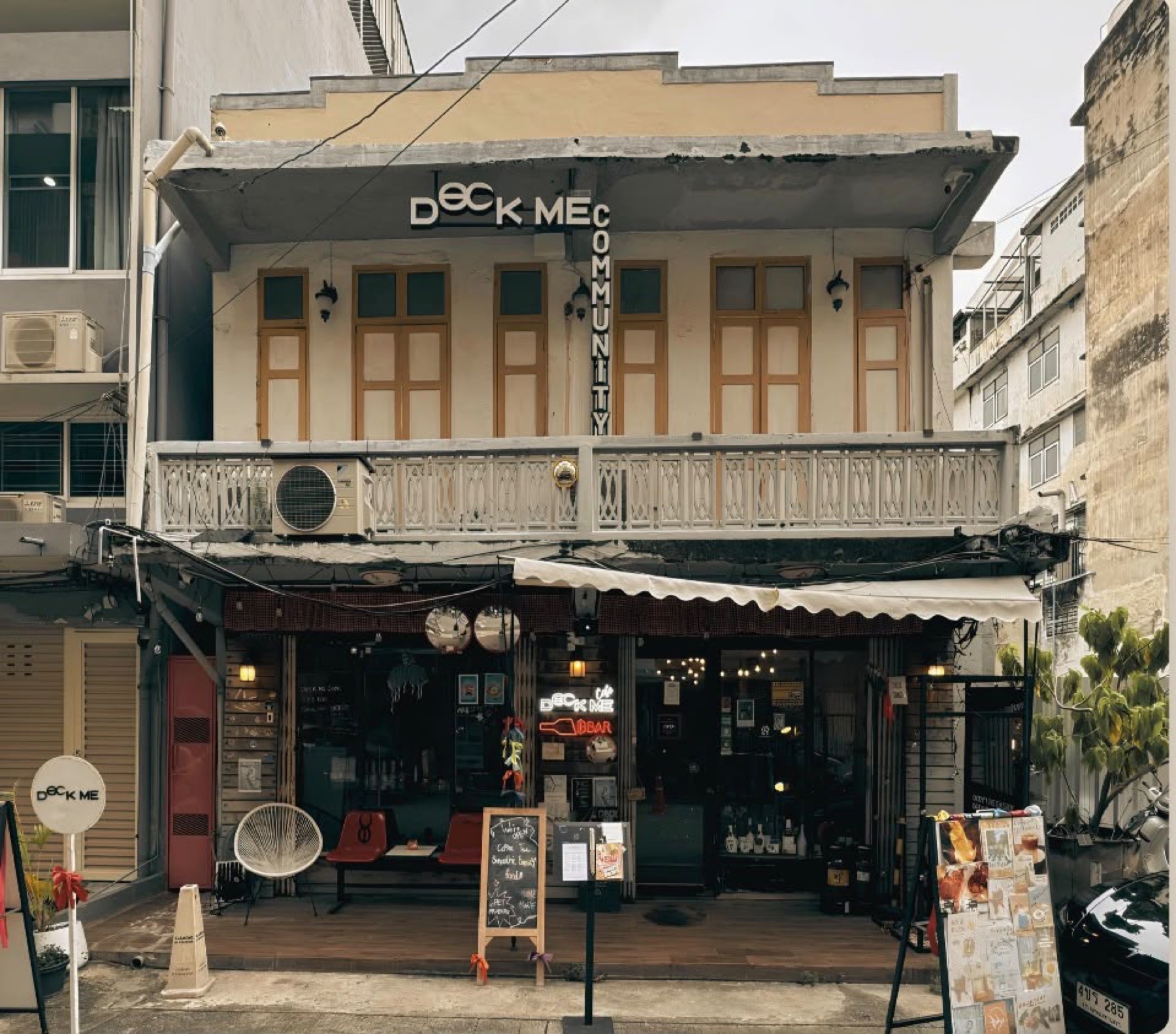 The shophouse front before the refit, with a previous café's signs and awning