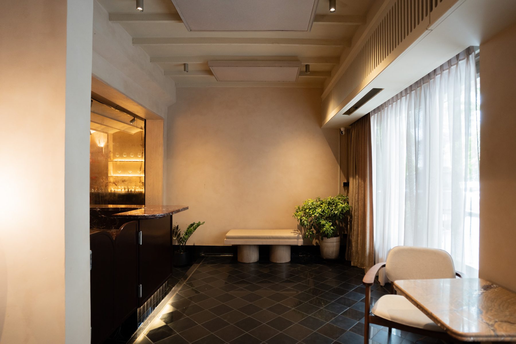 The ground floor with the bar, tables and tall curtained street windows